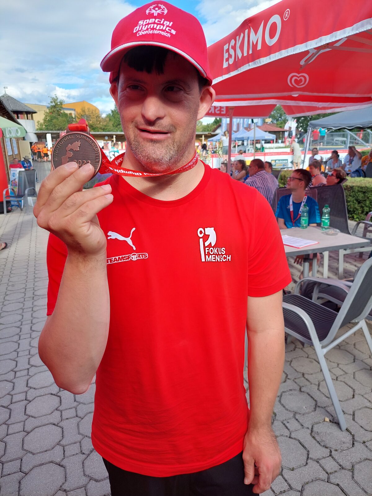 Medaillengewinner hält seine Bronze-Medaille stolz in die Kamera